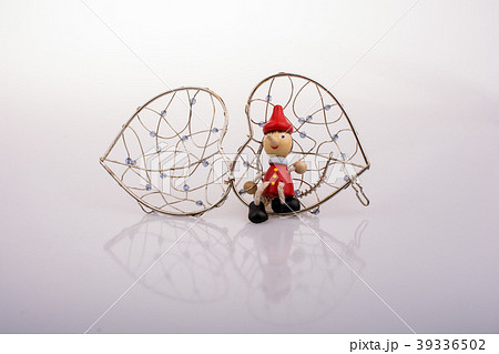 Pinocchio doll sitting on a heart shaped cage Pinocchio doll sitting on a heart shaped cage 39336502