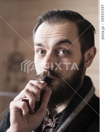 Man with Beard and Mustages Vaping an Electronic 39343397