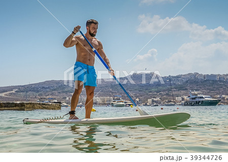 Man paddle boarding in blue sea 39344726