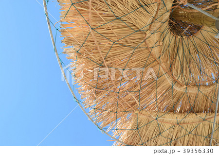 Straw parasols at the beach in summer 39356330
