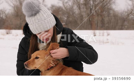 Beautiful girl strokes and feels sorry for her dog 39356690