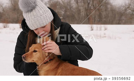 Beautiful girl strokes and feels sorry for her dog 39356692