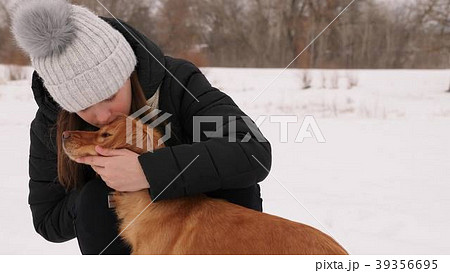 Beautiful girl strokes and feels sorry for her dog 39356695