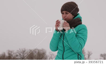 Frozen girl warms herself with hot mug in the Frozen girl warms herself with hot mug in the 39356721