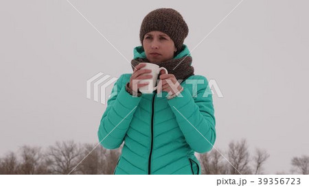 Frozen girl warms herself with hot mug in the Frozen girl warms herself with hot mug in the 39356723