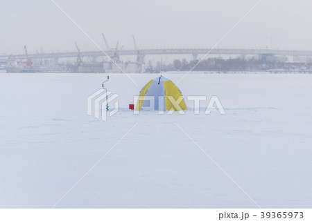 Ice fishing equipment: tent, drill, bucket on ice 39365973