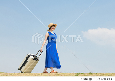 女子旅 キャリーバッグを引く若い女性の写真素材