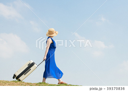 女子旅 キャリーバッグを引く若い女性の写真素材