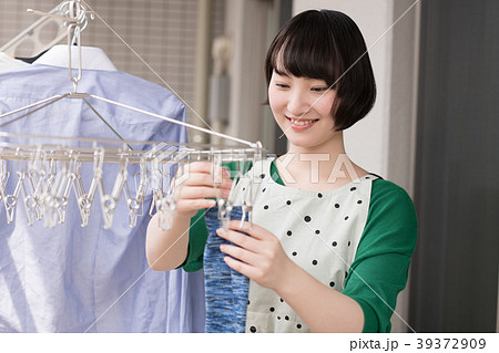ベランダで洗濯物を干す若い女性 39372909