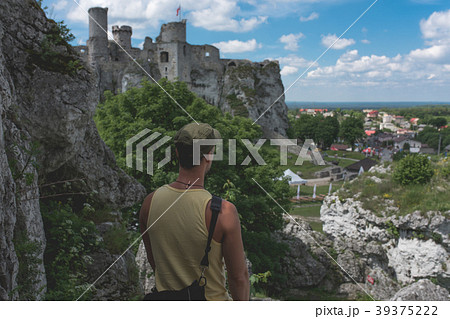 Man standing on the cliff,castle in the distance 39375222