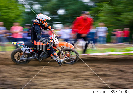 MX rider turns in a dirt. Motion blur with panning 39375402