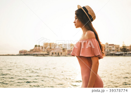 Stylish brunette woman enjoying sunrise on seafront Stylish brunette woman enjoying sunrise on seafront 39378774