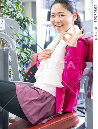 フィットネスジムで体を運動する女性　OKサイン 39379366