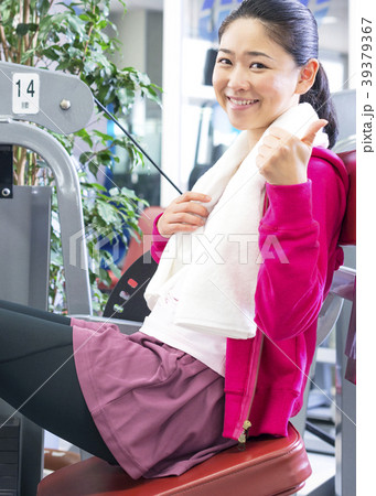フィットネスジムで体を運動する女性　グッドサイン 39379367