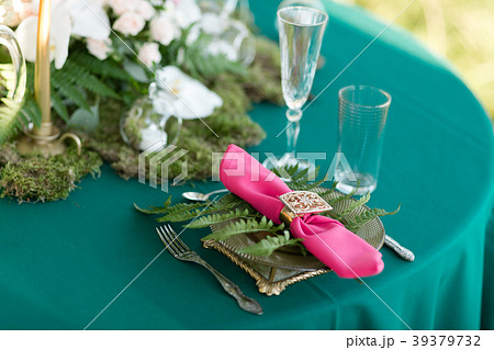 Pink napkin with a patterned clip. table setting Pink napkin with a patterned clip. table setting 39379732