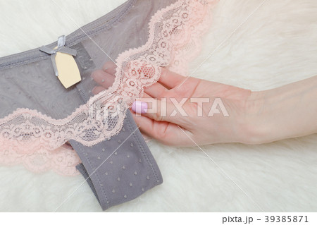 Gray lace panties in female hand. White background Gray lace panties in female hand. White background 39385871