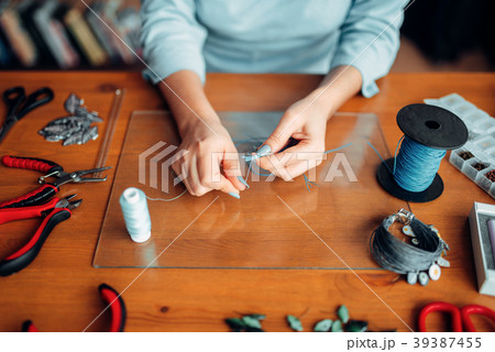 Female hands with pliers, top view, needlework Female hands with pliers, top view, needlework 39387455