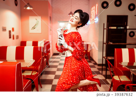 Pinup girl drinking carbonated drink in retro cafe 39387632