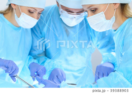 Group of surgeons at work while operating at 39388903