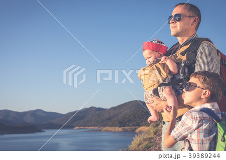 Happy family standing near the lake at the day time. 39389244