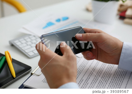 A businessman holds a new smartphone in 39389567