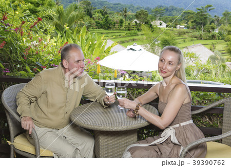 man and the woman with glasses sit on a balcony ov 39390762
