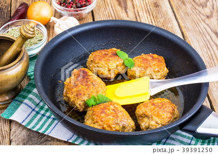 Frying pan with fried cutlets on wooden table 39391250