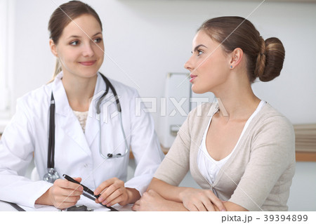 Doctor and  patient  sitting at the desk. T 39394899