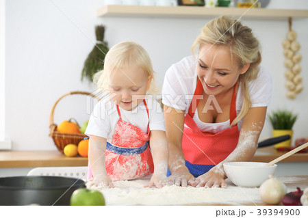 Little girl and her blonde mom in red aprons Little girl and her blonde mom in red aprons 39394900