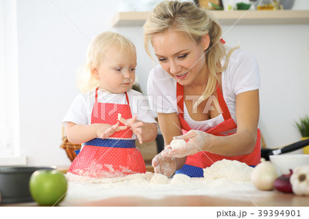 Little girl and her blonde mom in red aprons Little girl and her blonde mom in red aprons 39394901