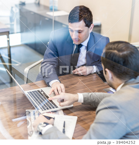 Two young businessmen using laptop computer at Two young businessmen using laptop computer at 39404252