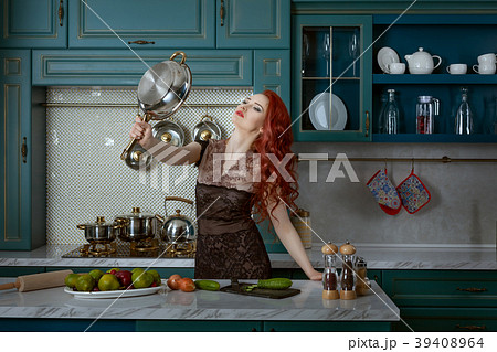 Red-haired woman holds a frying pan. 39408964