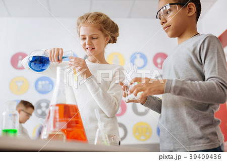 Joyful teenage girl pouring chemical into test 39409436