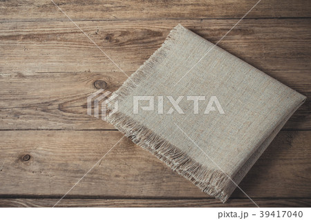 Folded linen napkin on old wooden kitchen table Folded linen napkin on old wooden kitchen table 39417040