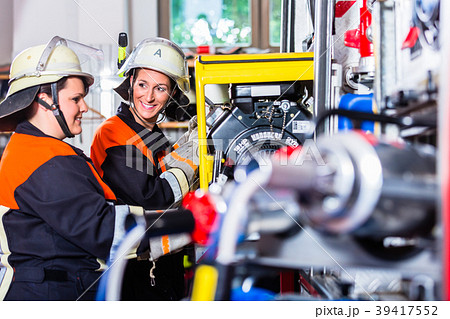 Fire fighters loading hoses into operations 39417552