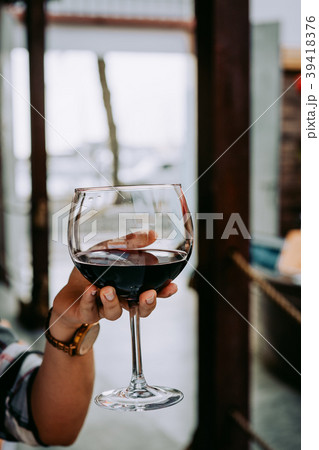 Woman hand holding a wine glass with red wine Woman hand holding a wine glass with red wine 39418376