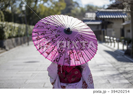 京都府京都市東山区祇園町の円山公園で和傘をさしている着物姿の若い女性の後ろ姿の写真素材