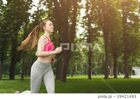Young woman running in green park, copy space 39421483