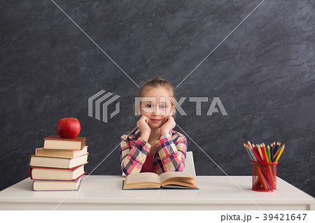 Cute smart girl smiling while sitting with books 39421647