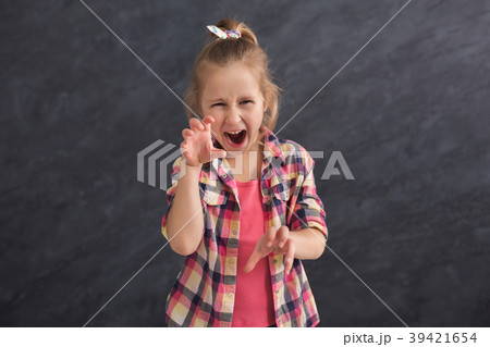 Funny little girl imitating cat on dark background Funny little girl imitating cat on dark background 39421654