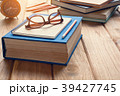 Books and glasses on a wooden table desk 39427745