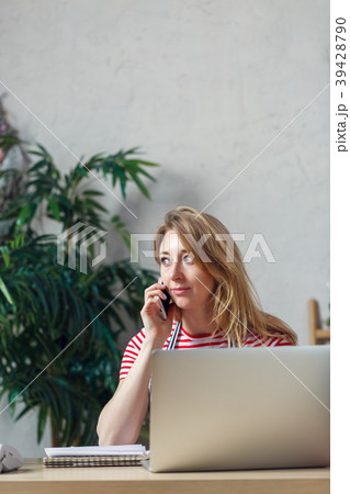 Picture of blonde florist talking on phone sitting 39428790