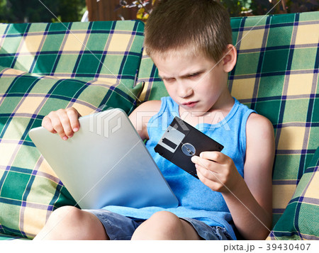 Little boy with floppy disk and tablet pc 39430407