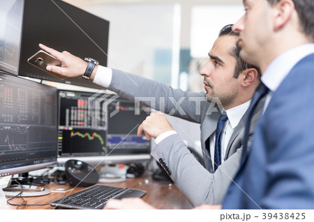 Stock brokers looking at computer screens, trading 39438425