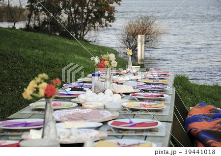 fancy picnic table full of food by lake in spring 39441018