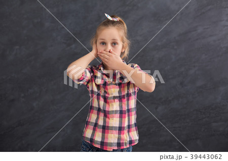 Little girl covering mouth and ear with hands Little girl covering mouth and ear with hands 39443062