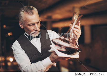 Experienced sommelier looks at wine  in decanter.  39443477