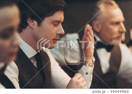 Young handsome sommelier man tasting red wine  39444960