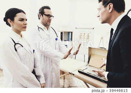 Businessman asks the doctor to take the money Businessman asks the doctor to take the money 39446615