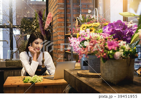 Women florist looking laptop got order at counter of her flower Women florist looking laptop got order at counter of her flower 39451955